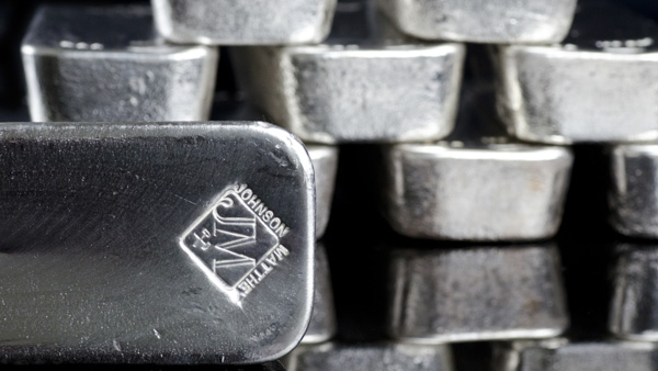 Image: A stack of silver bullion bars, with one bar in the foreground displaying the Johnson Matthey logo.